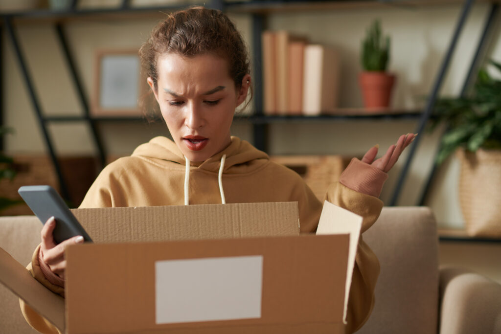 Displeased woman opening a parcel